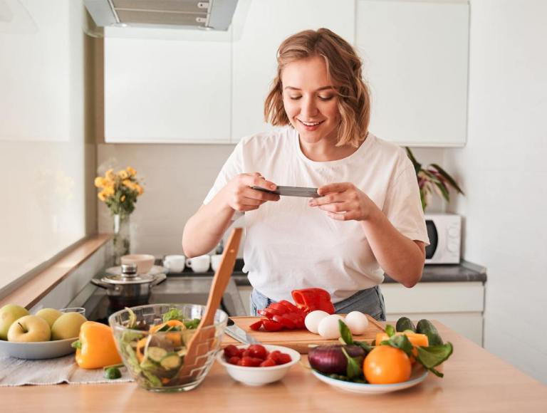 Female taking a photo of food items on a cutting board - image used for Dangerous TikTok Food Trends