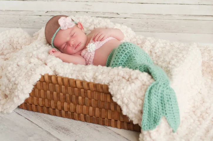 Newborn Baby Girl Wearing a Mermaid Costume Sleeping in Basket