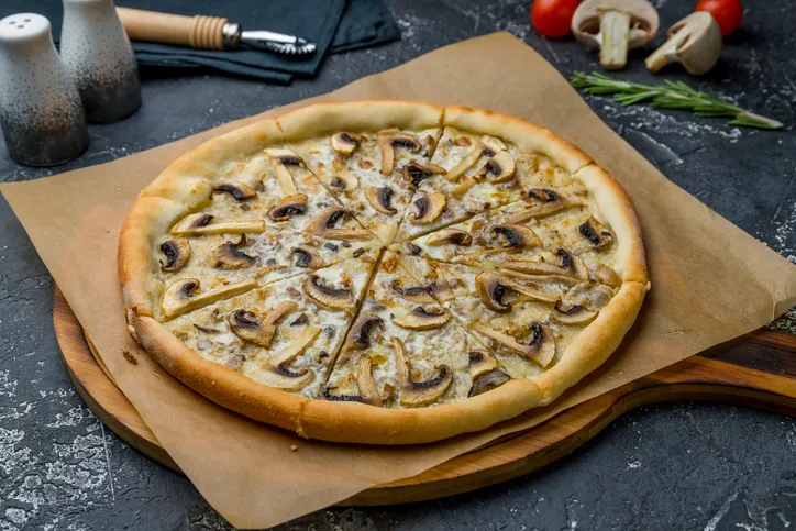 pizza with mushrooms on dark grey concrete table