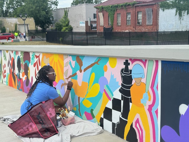 lady working on her colorful mural
