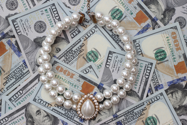 Coral necklace on the background of dollar bills.