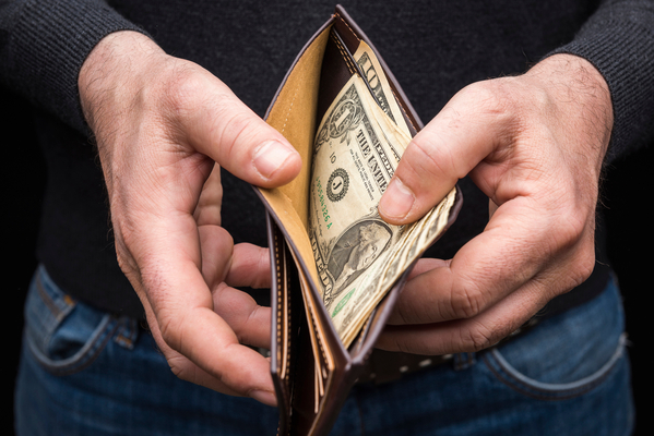 Hands holding a wallet with a small amount of US dollars, close up